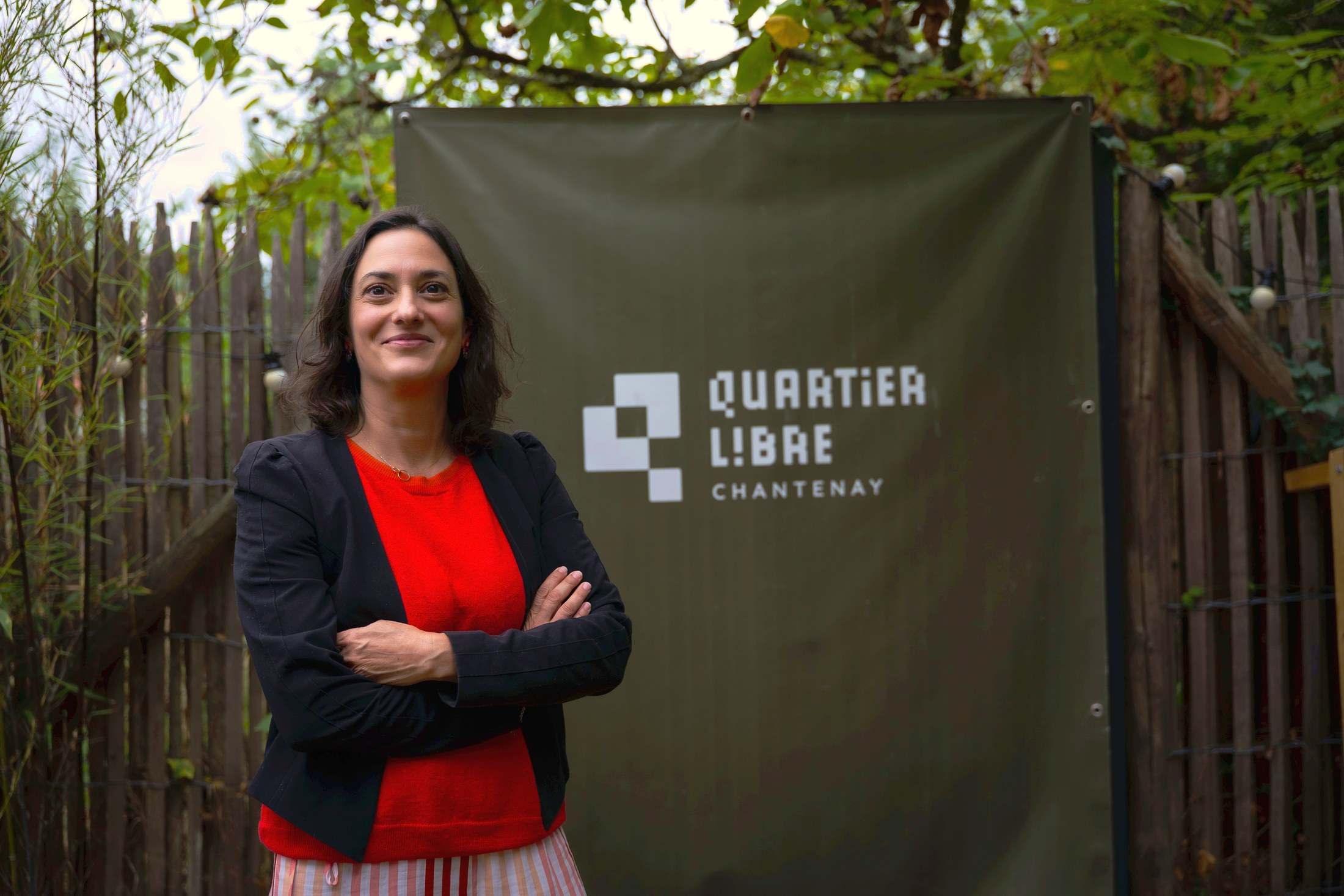 Clothilde Van Ghele devant la bâche Quartier Libre Chantenay, dans le jardin